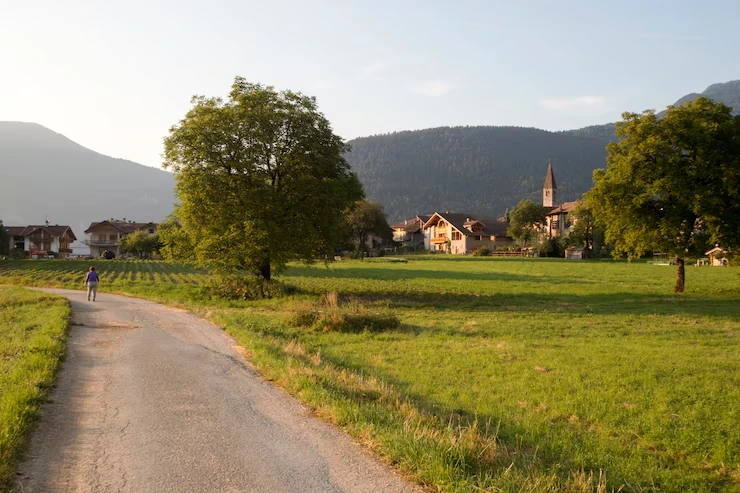 person-jogging-on-rural-road-with-mountains-and-houses-in-background